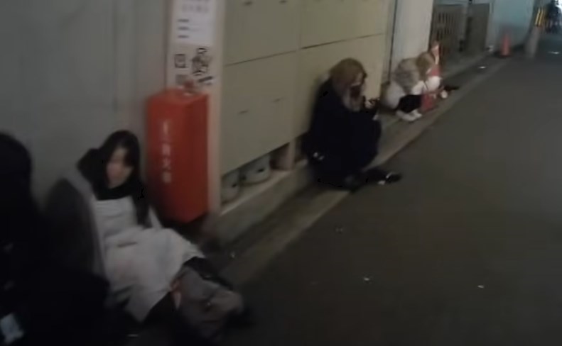 兎我野町の裏通りに座る女性